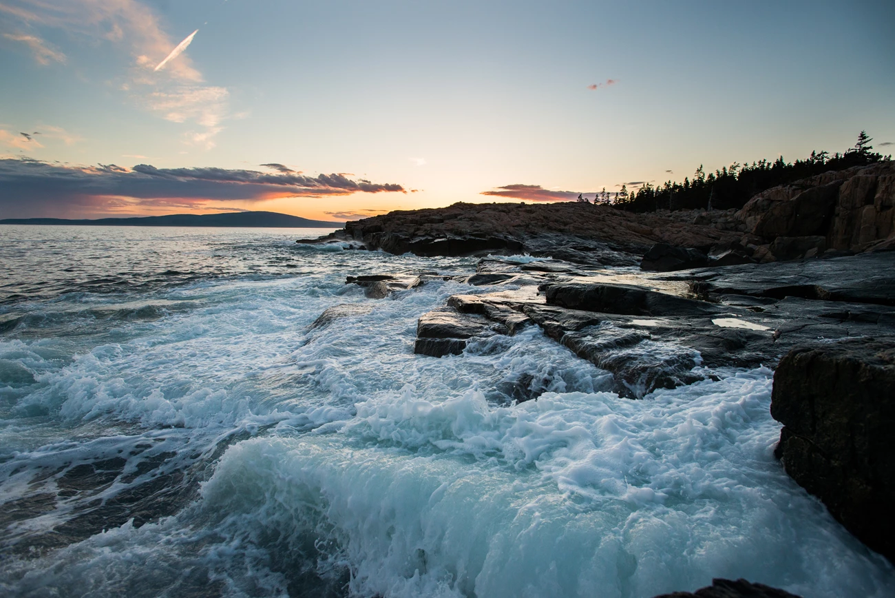 Sunset at Schoodic Peninsula Waves crashing over a rocky coastline at sunset