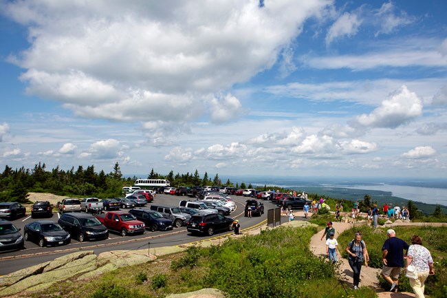 Congested parking area and trail on a mountain summit