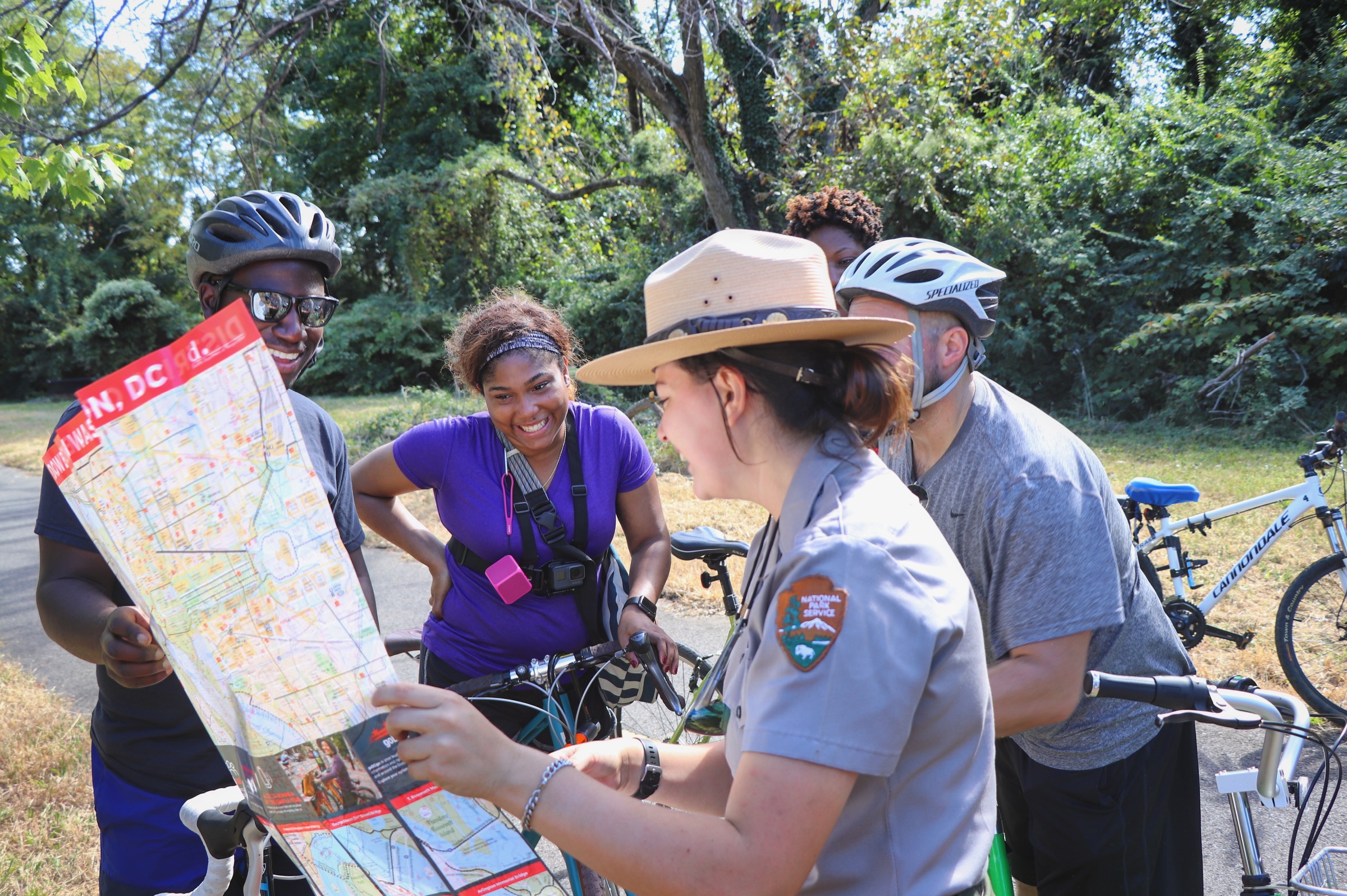 Park ranger provides directions with map to visitors on bikes on the Anacostia Riverwalk Trail