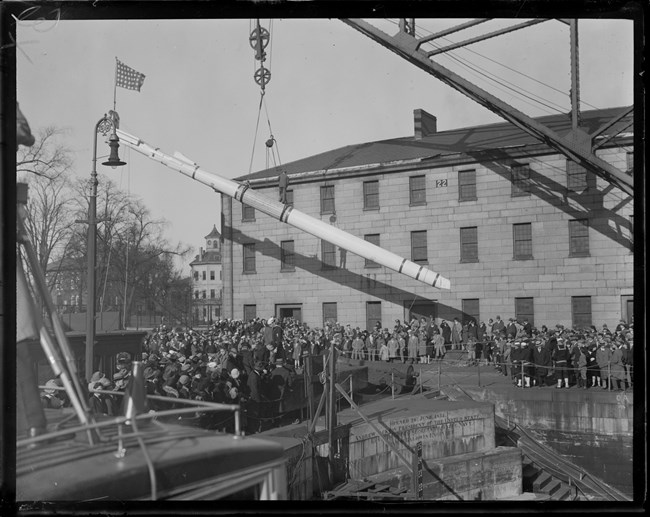 Portal Crane lifting up the mast of a ship.