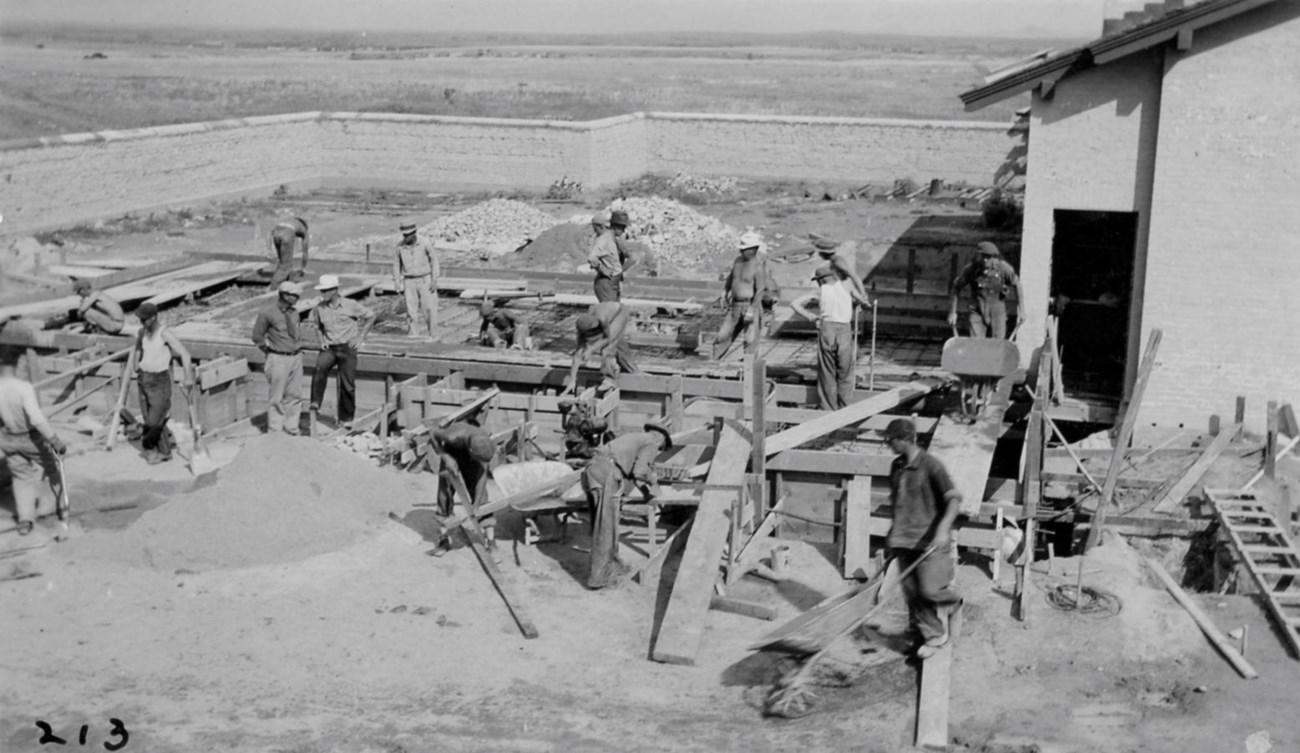 CCC workers building Visitor Center addition A group of men work on the foundation of a building.