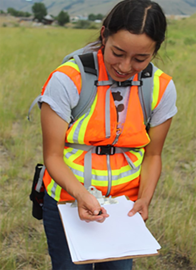 2019 NANRP Serra Ferris_Student Testimonial_web A woman in an orange safety vest records data.