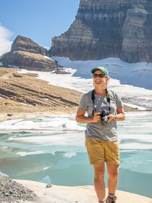 Lisa McKeon at Grinnell in 2020 A person smiling in front of an icy lake holding a camera
