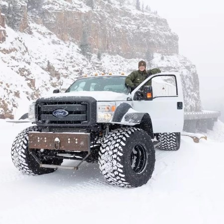 Delivering Mail During Winter a park ranger standing in the door of a big truck in winter