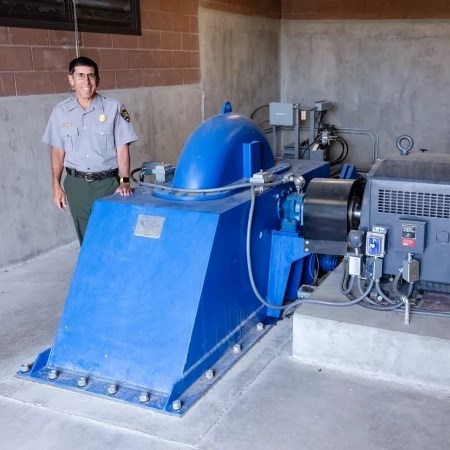 Maintaining a Micro Hydroelectric Generator a park ranger standing next to a large generator
