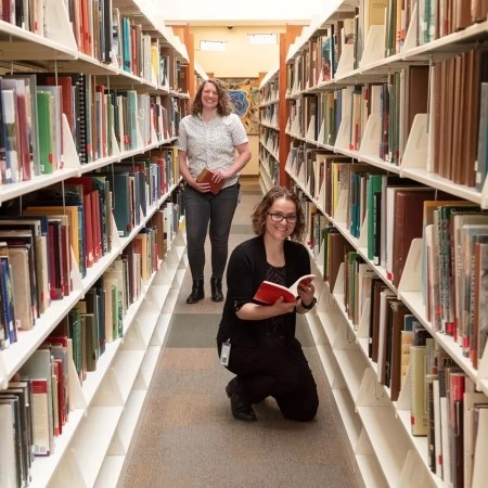 Maintaining Library Collections two people standing in a library aisle