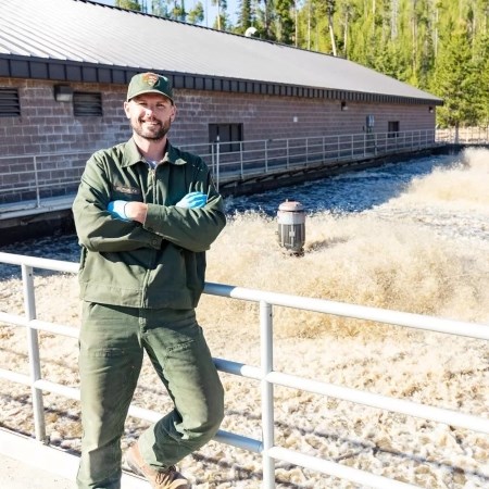 Treating Wastewater a park ranger leaning against a railing and smiling