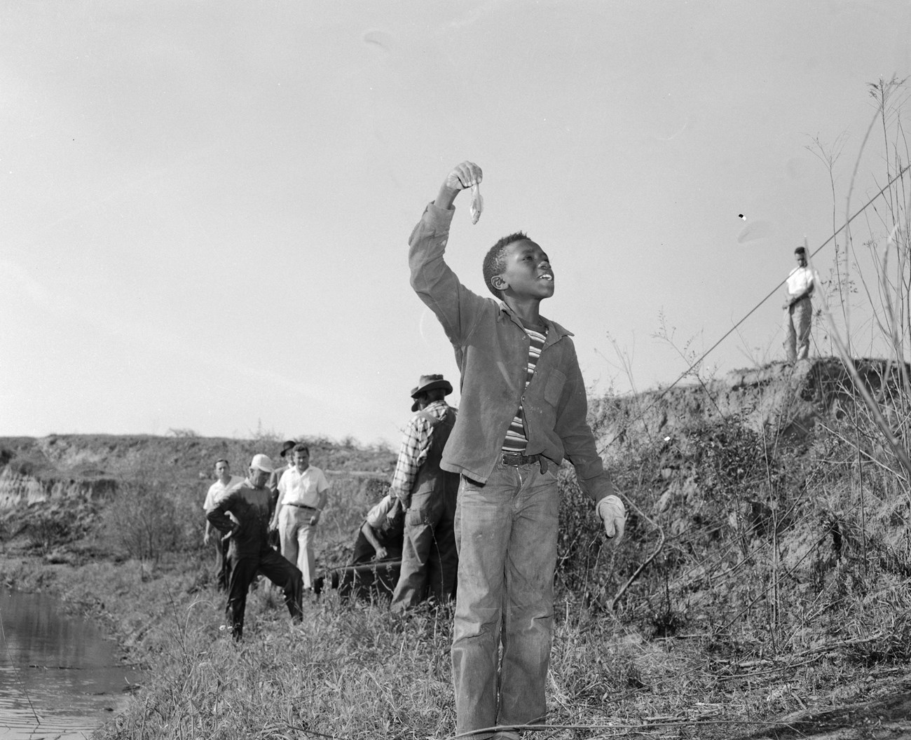 Boy holding a small fish he caught in a creek in Phenix City, Alabama. Boy holding a small fish