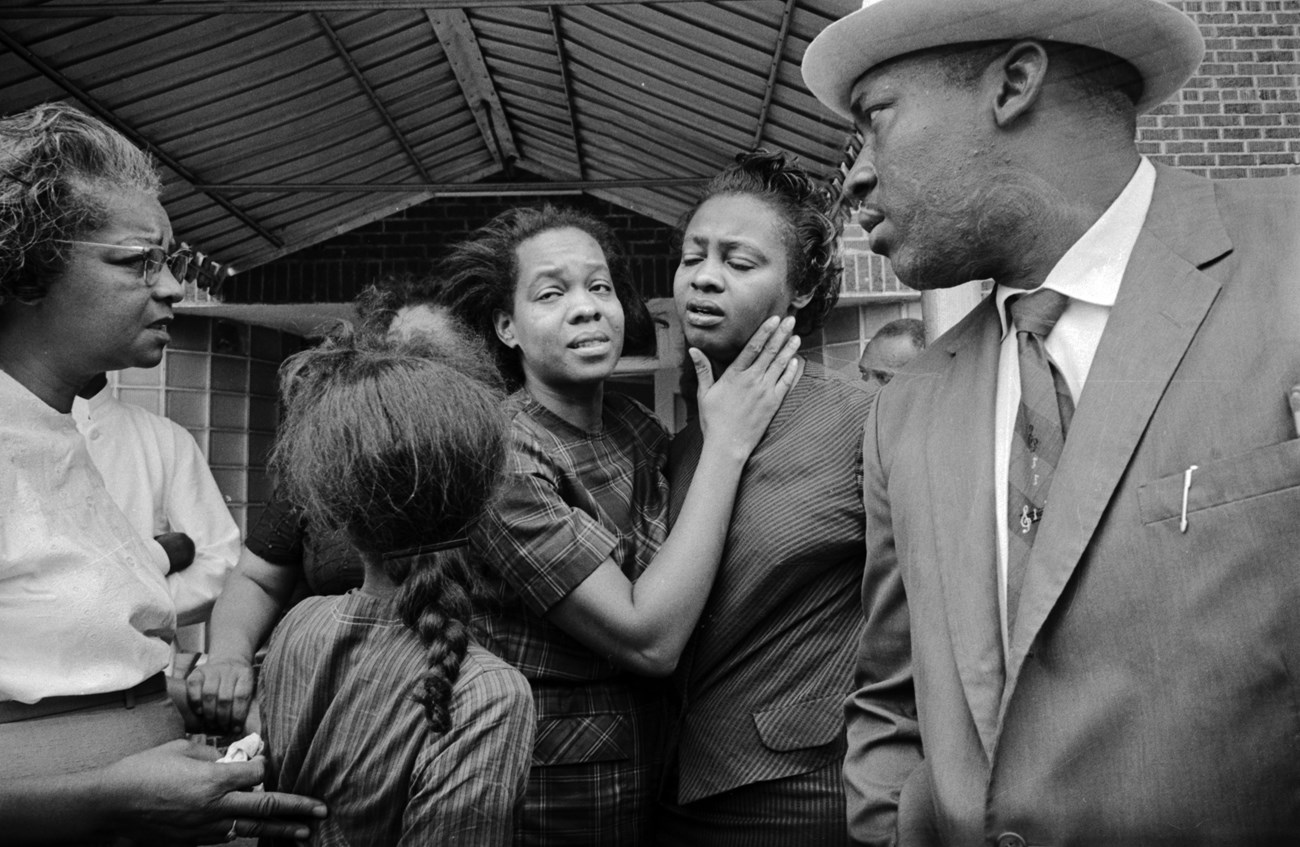 Juanita Jones hugging her sister, Maxine McNair (mother of bombing victim Denise McNair), in front of Social Cleaners across the street from 16th Street Baptist Church, after the building was bombed.