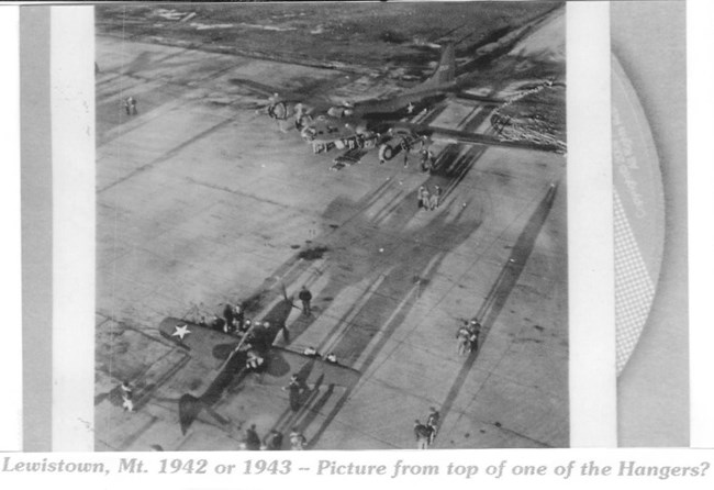 Black and white overhead photo of the tarmac  with a plane in the bottom left hand corner