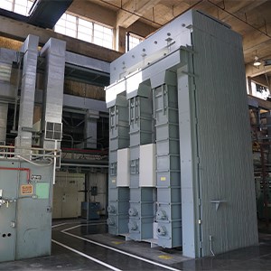 A large bluish-grey metallic structure inside a large warehouse.
