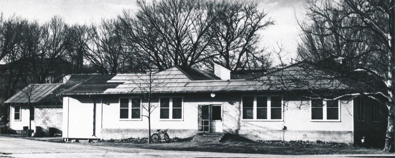 Black and white photo of a small one-story building.