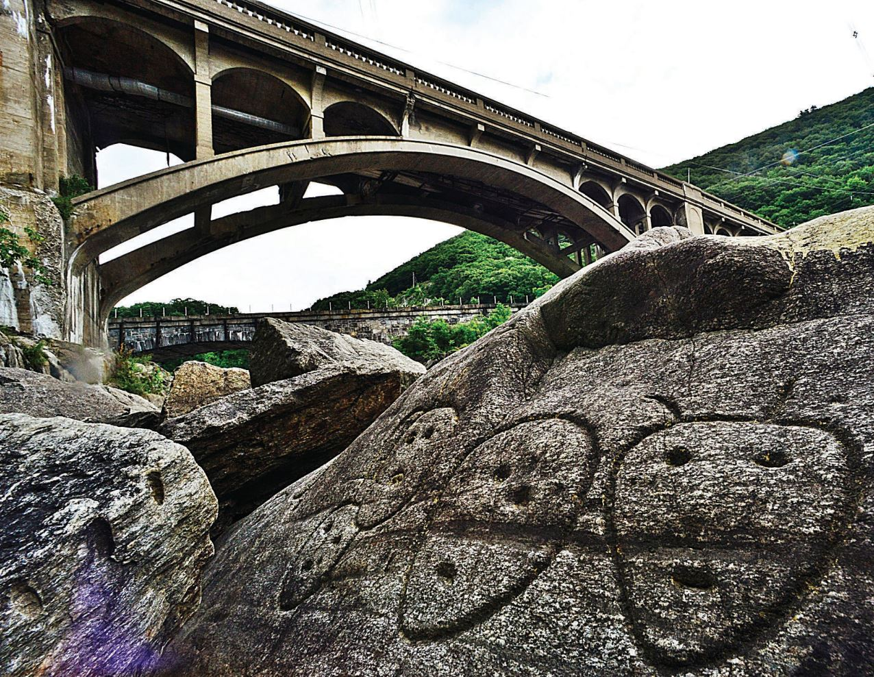 Petroglyphs below a large bridge