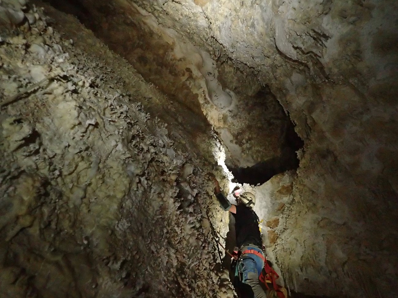 a person climbing up a cave passage