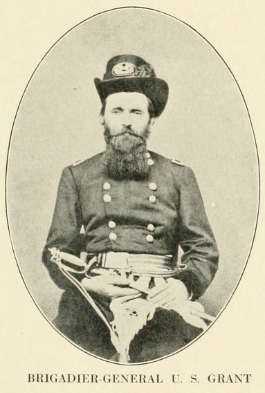 Black and white image of US Grant with a beard and hate facing the camera while on a stool in civil war uniform, text below