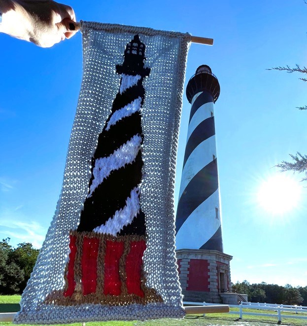 Completed crochet pattern of Cape Hatteras Lighthouse with Lighthouse and sun in background.