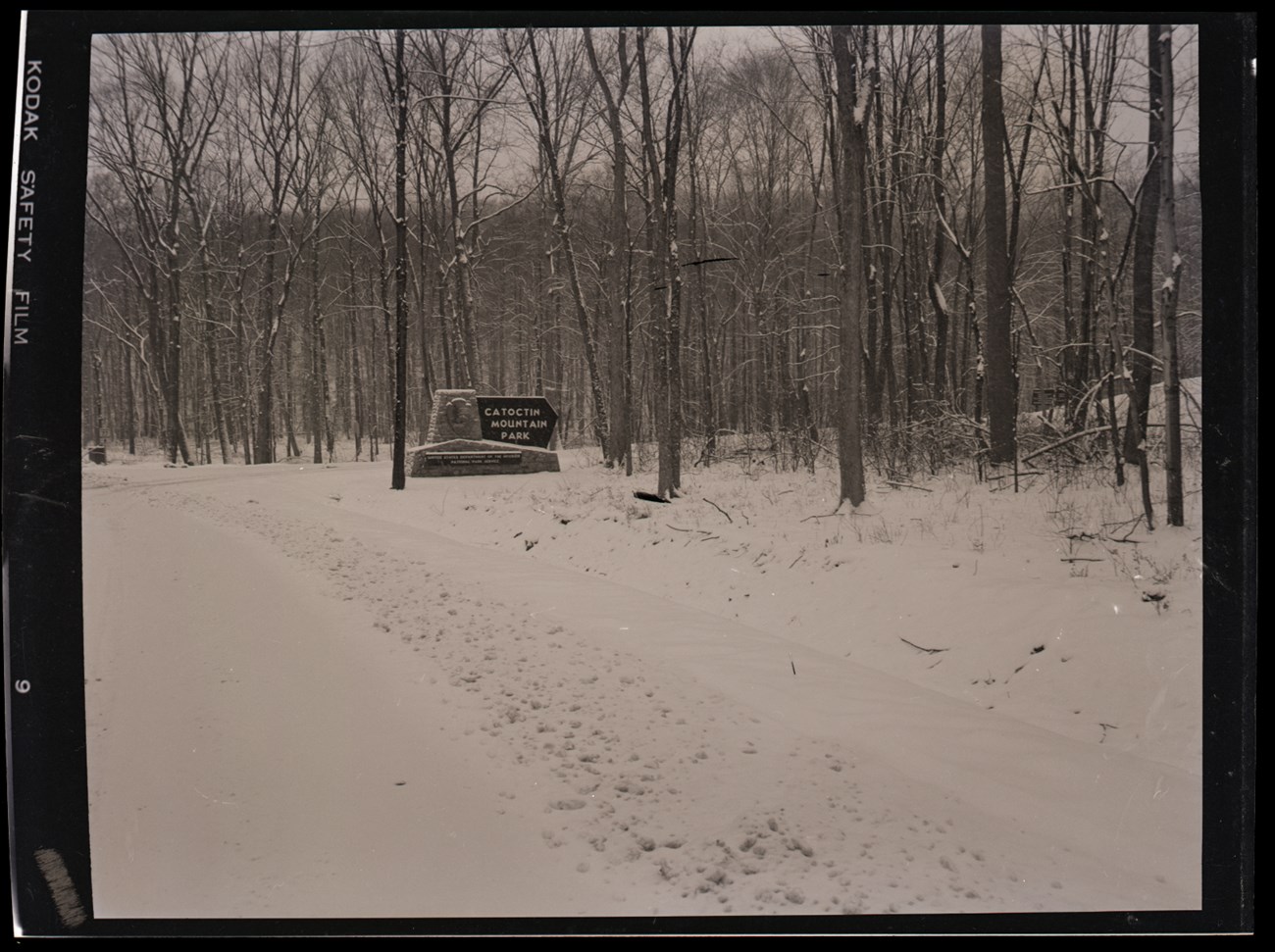 Image of a digitized color negative showing the sign and entrance to Catoctin Mountain Park after a snowfall.