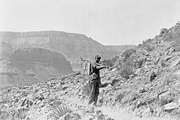 A black and white picture of a Black man stands on the trail at Grand Canyon A black and white picture of a Black man stands on the trail at Grand Canyon