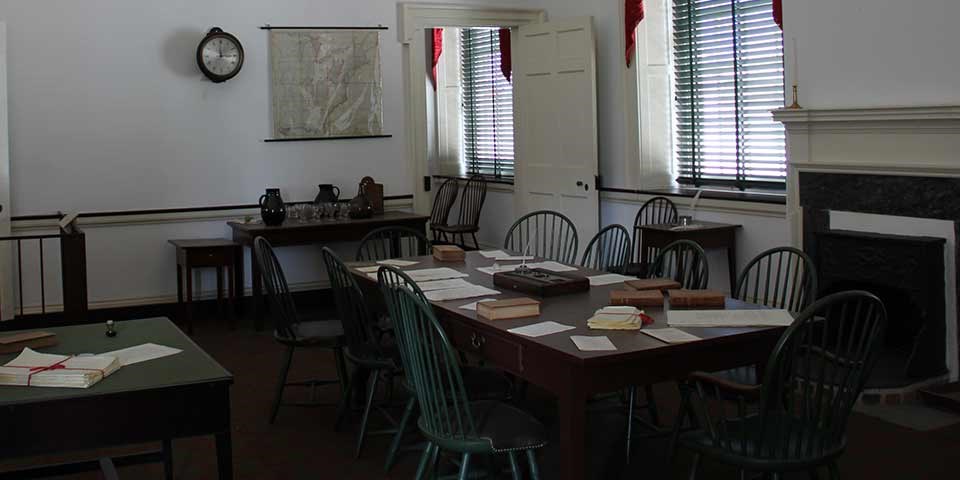 Committee room from the 1700s with Windsor chairs surrounding a wooden table in the center of the room. Committee room from the 1700s with Windsor chairs surrounding a wooden table in the center of the room.
