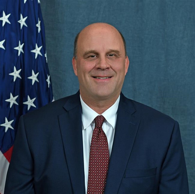 Associate Director Mike Caldwell Headshot of a smiling man in front of a blue backdrop