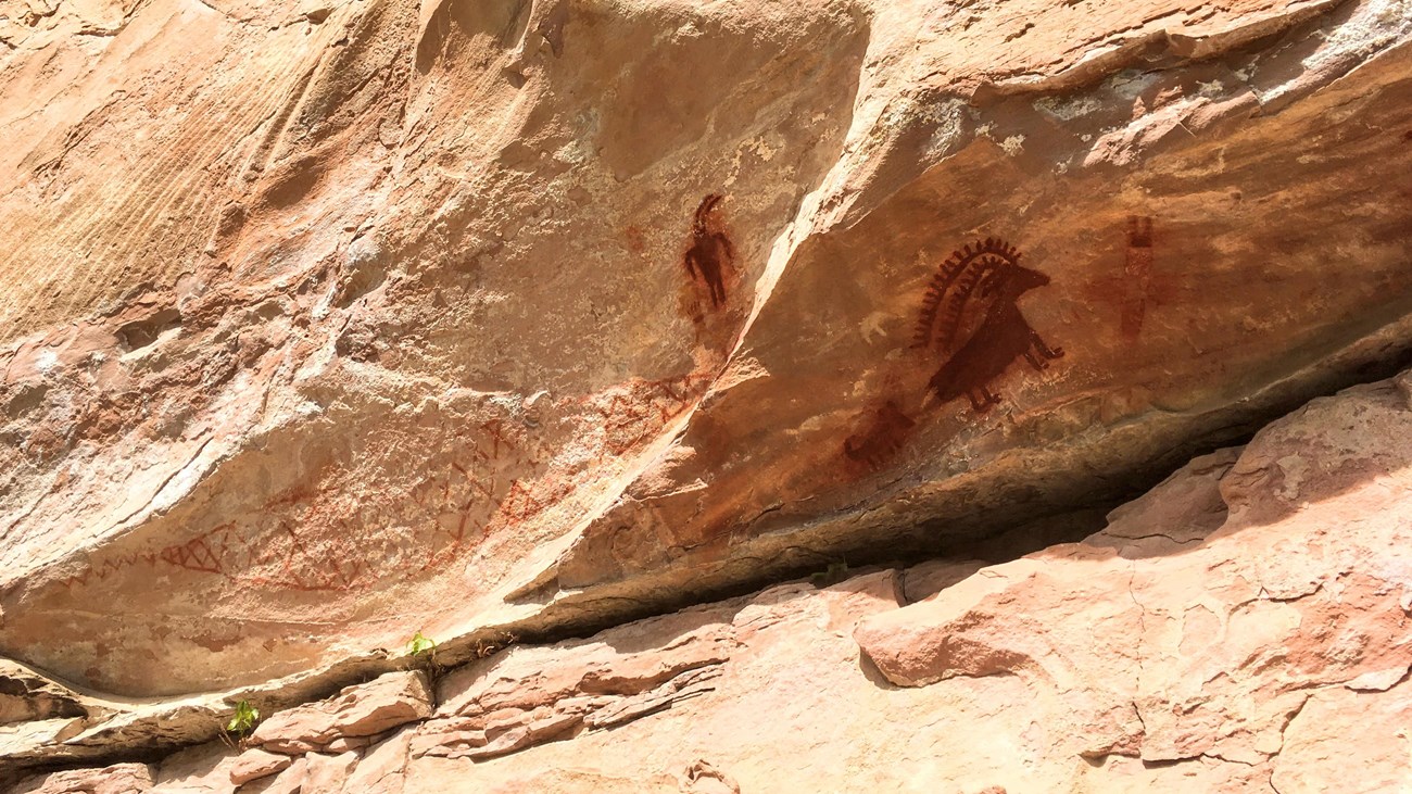 Red painted images on a rock face