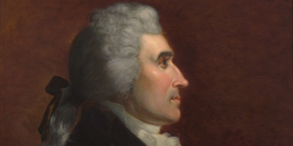 Profile portrait of Dayton in black coat and hair pulled back.