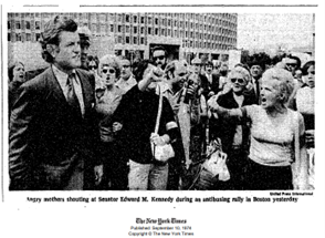 Senator Kennedy on the left with a crowd of people to his side.