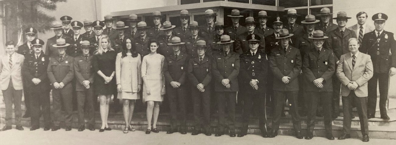 Police officers and rangers standing in rows posing for a class photo