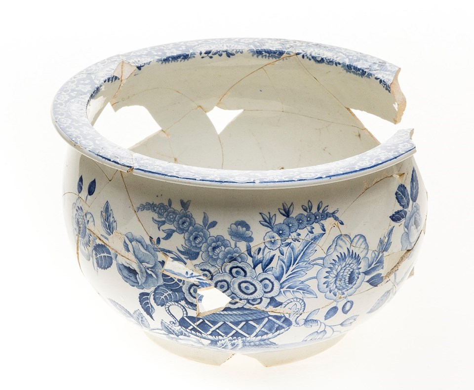 Rounded ceramic chamber pot, white earthenware decorated with a blue floral design.