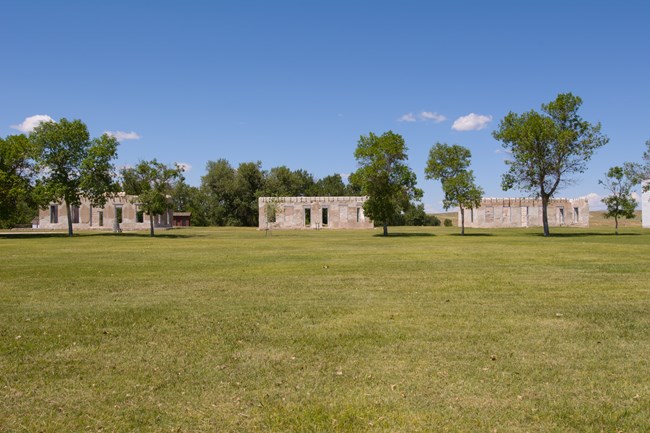 A green lawn stretches back to a distant historic fort.