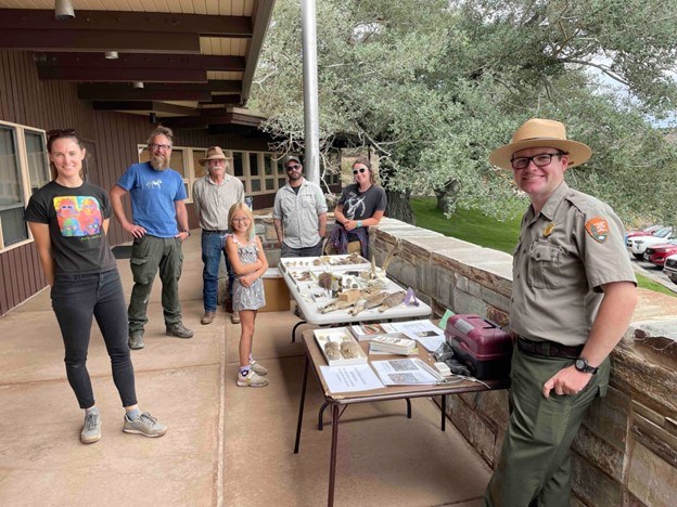 Park ranger stands next to table with various animal bones