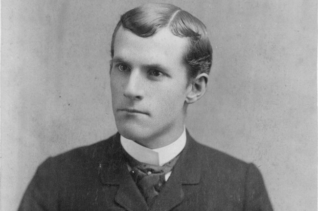Black and white photo of Manley Bostwick Haynes wearing a suit as he glares at an angle from the camera.