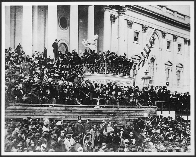 Large crowd gathered on the steps of the US Capitol with Lincoln at a podium at the center.