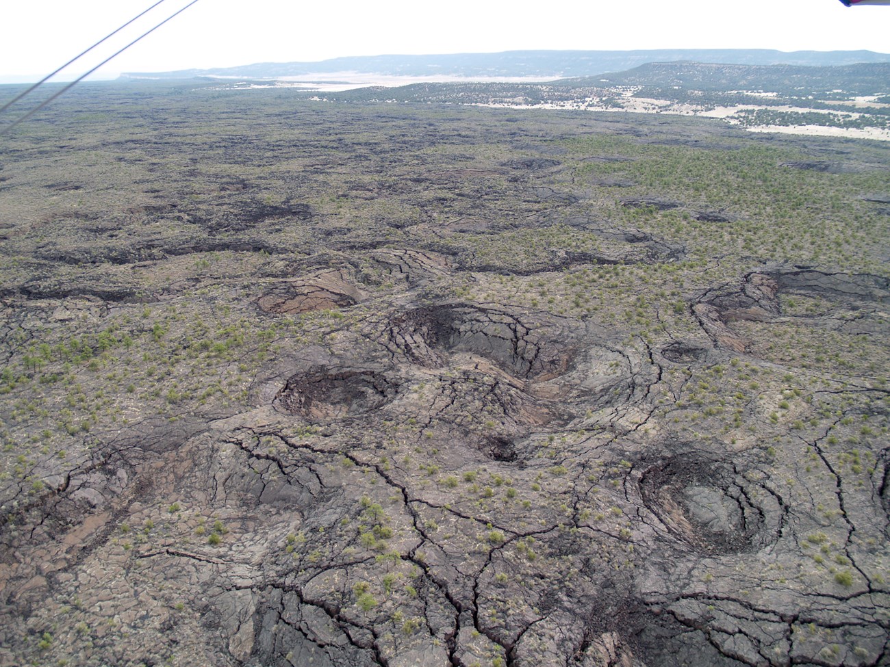 photo of rocky land surface with cracks and rounded pits