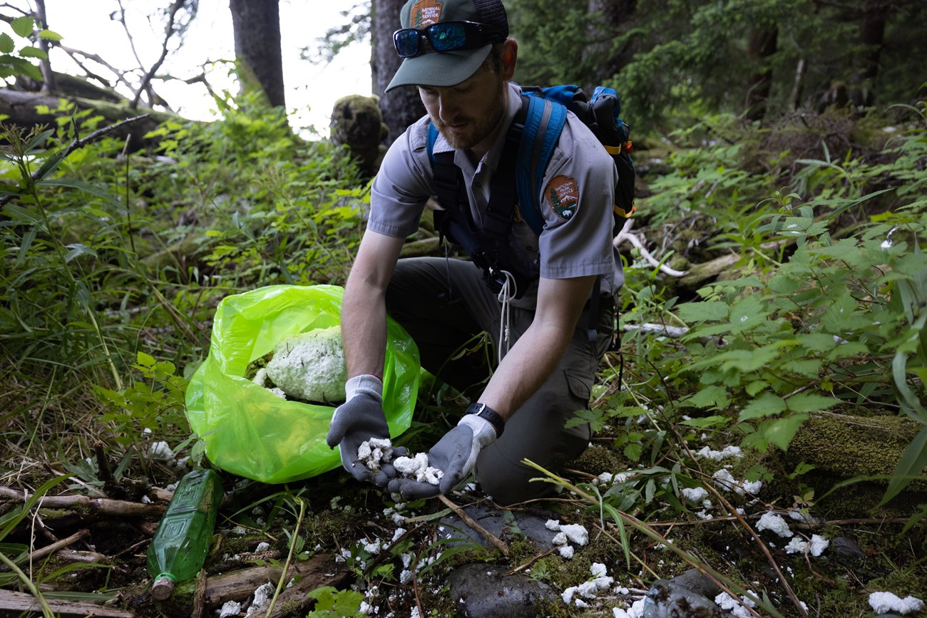 A ranger cleans marine debris and ocean plastics from the coast of Kenai Fjords National Park.