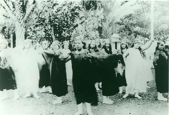 Black and white photo of group of Hawiian youth in costumes.