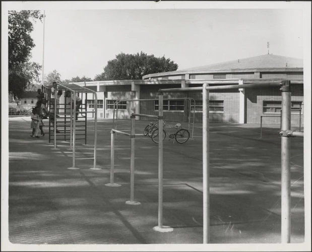 Katherine B. Richardson Elementary School LaBudde Collections Katherine B. Richardson Elementary School playground, with three children on monkeybars, and two bicycles