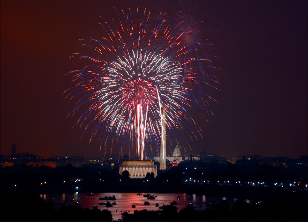 Fireworks over Washington D.C. Red and purple fireworks explode over Washington D.C. at night, highlighting the Lincoln Memorial in the foreground