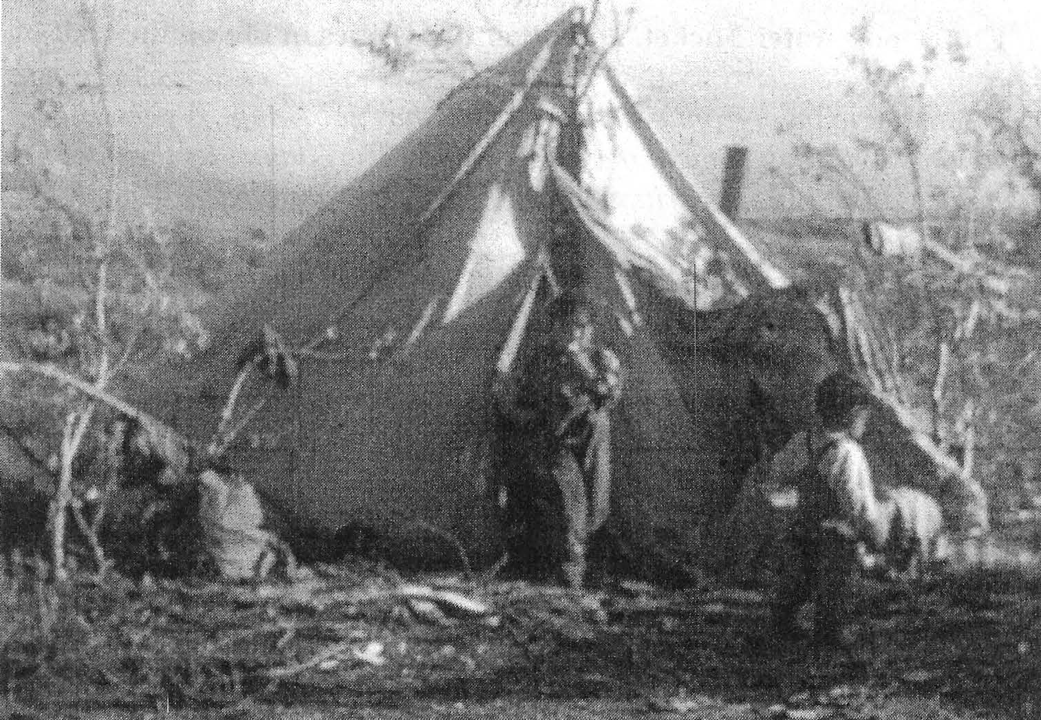 Black-and-white photograph of Nunamiut children and a wall tent on the tundra
