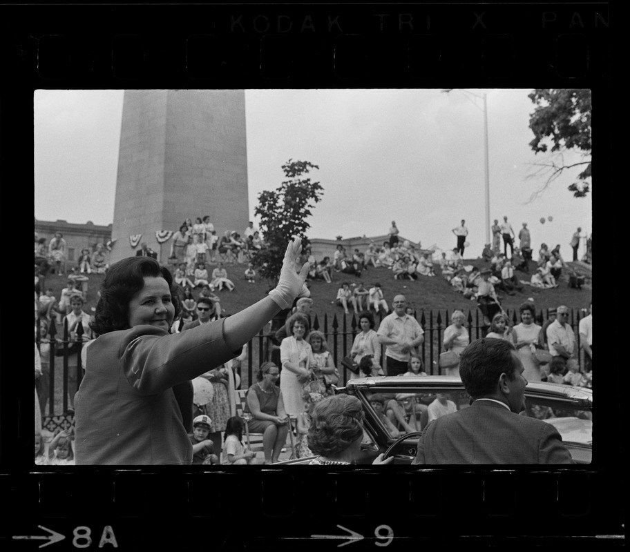 Louise Day Hicks waves at people in the crowd while passing the Bunker Hill Monuement