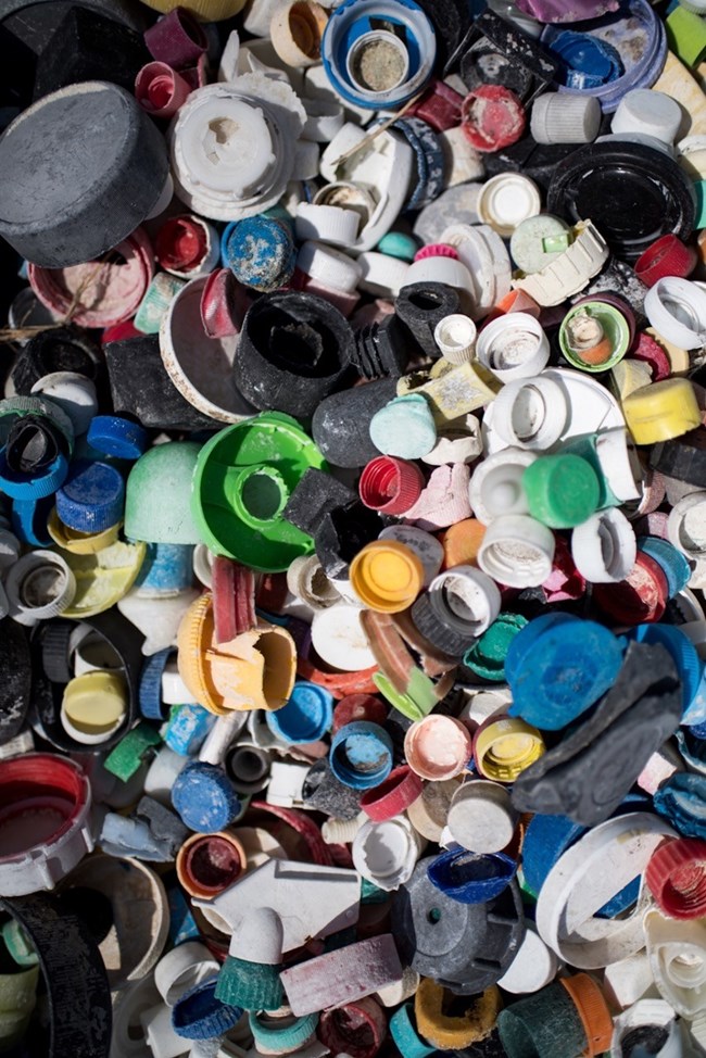 Numerous small pieces of plastic waste, mainly bottle caps in an assortment of colors.