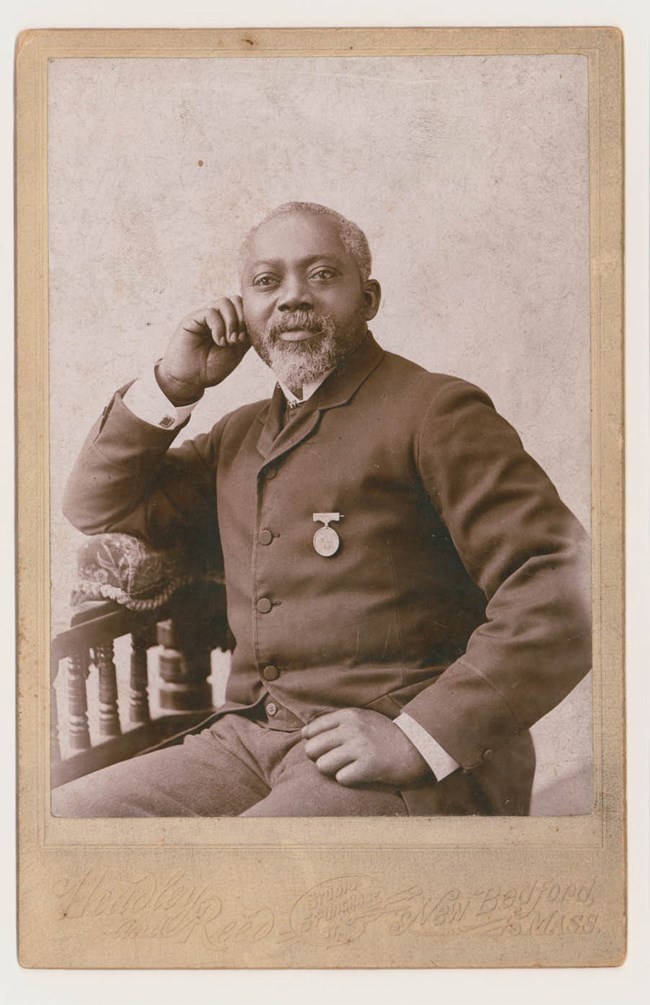 Civil War Veteran William Carney, an African American man in a suit with a medal.