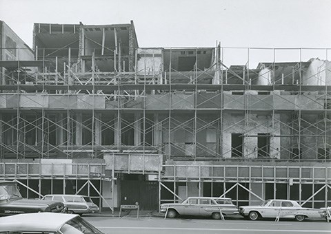 Market Street Houses, 1964 Black and white photo of brick row houses covered in scaffolding.