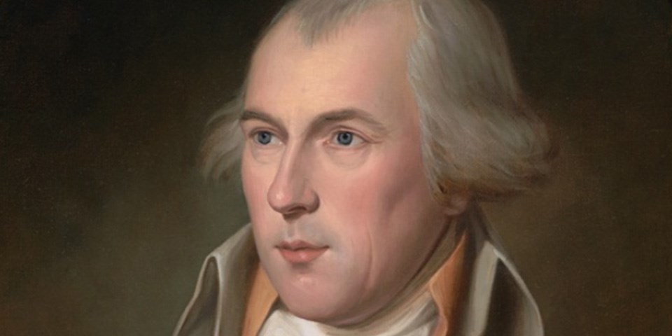 Portrait of James Madison wearing a grey coat with soft orange undercoat.