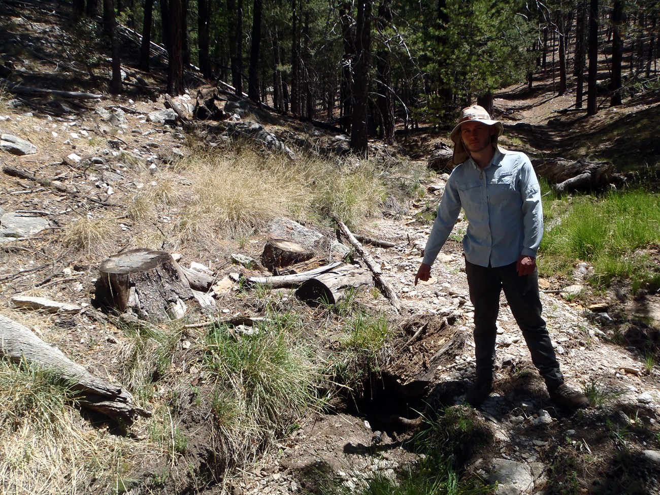 New Spring 3 A person pointing at a depression in the ground that is dry.