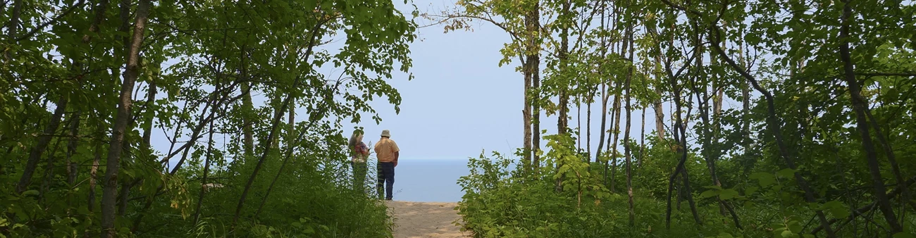 Log Slide Visitors Two people stand at an overlook
