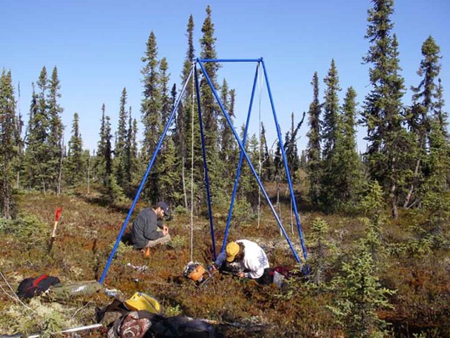 Researchers in the field take measurements of tundra.