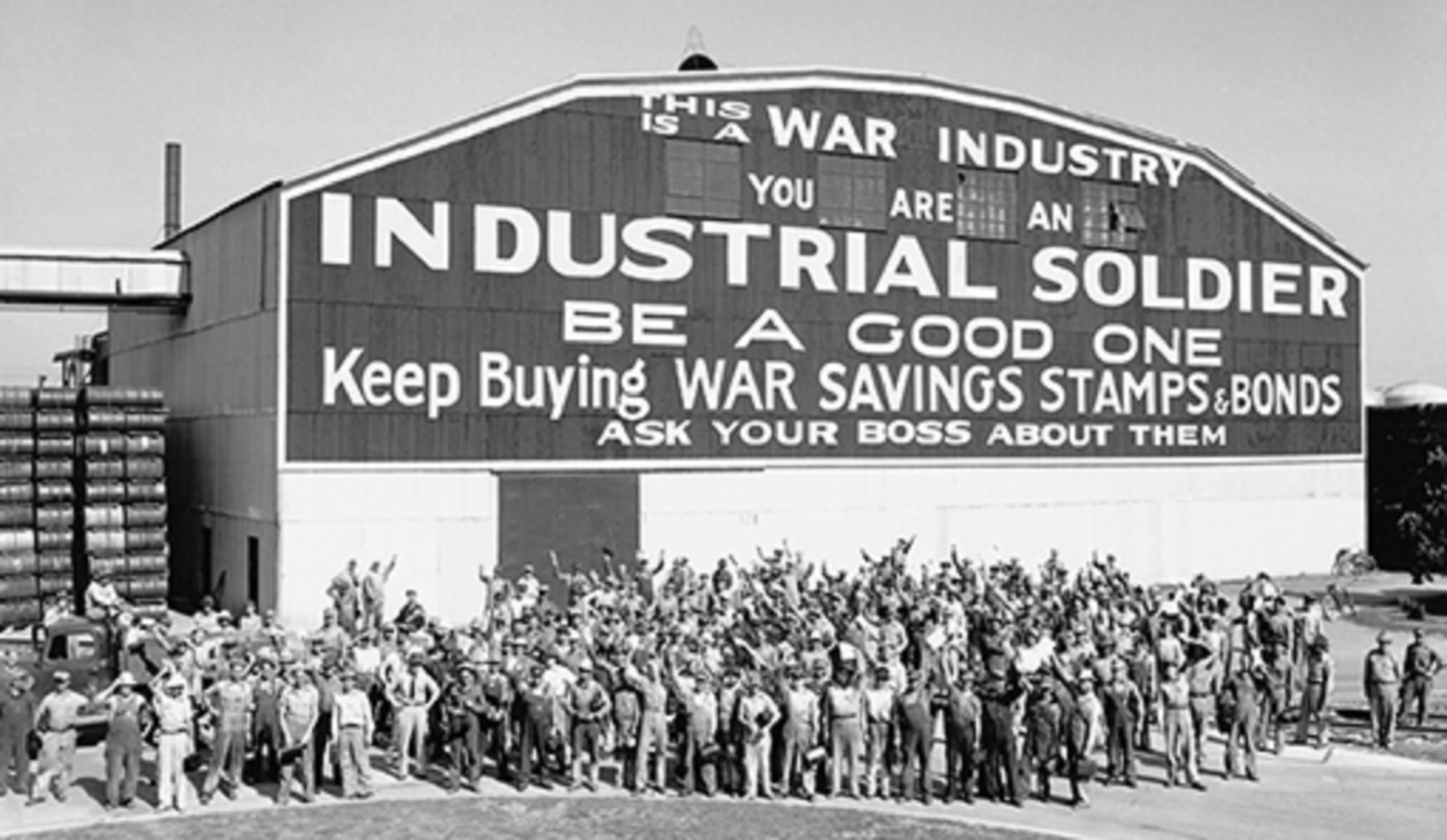 crowd gathered outside hangar building cheering war bond drive