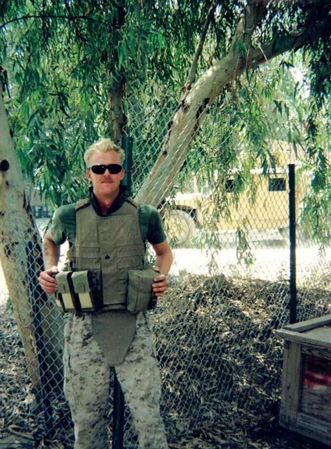 Steve Sabol, US Marines Veteran, stands outside in military attire under a tree.