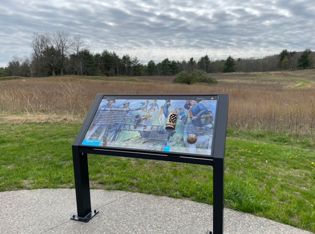 Interpretive panel at Tour Stop 5/Wheatfield where the 2nd Battle of Saratoga started.  Incorporated bronze tactile features of a case shot canister and a cannon ball.